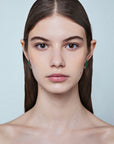 Model wearing the Rekhale gold rhombus earrings with natural stones, Italian luxury jewellery