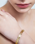 model wearing gadir gold bracelet with sculptural geometric pattern, handcrafted Italian fine jewellery
